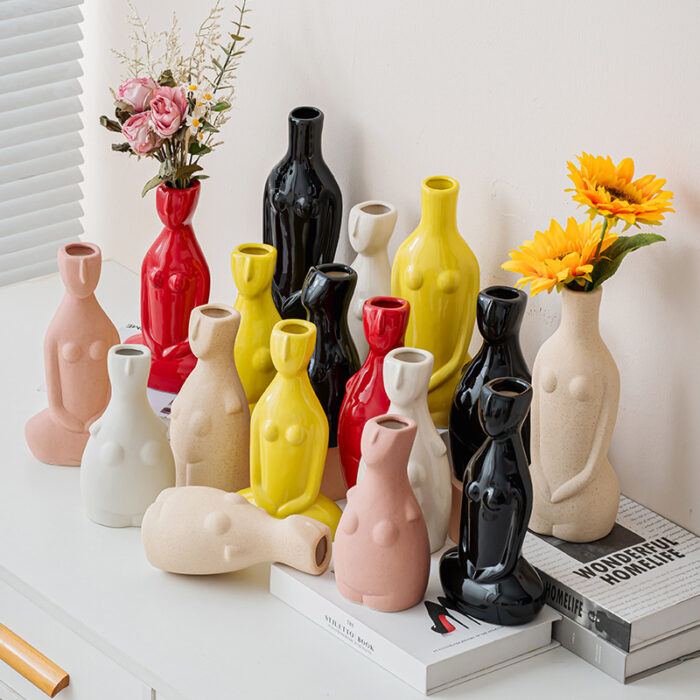 Abstract human body-shaped vases with flowers and books on white surface, HOMELIFE text decor