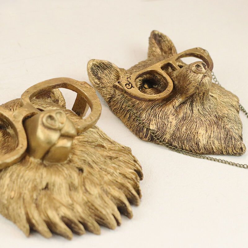 Gold-brown fox/wolf head wall decor pair with round patterned glasses & chain, asymmetrically arranged on pure white background | Vintage-inspired 3D faux taxidermy wall art