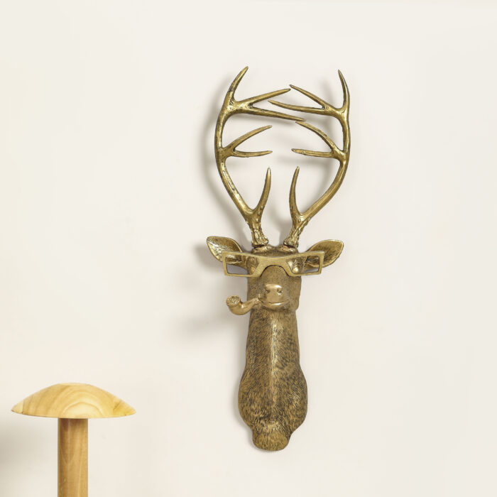 Gold faux deer head wall decor with square glasses & pipe, exaggerated antlers and textured fur details on white background, paired with wooden mushroom ornament | Whimsical 3D resin wall sculpture for rustic interiors
