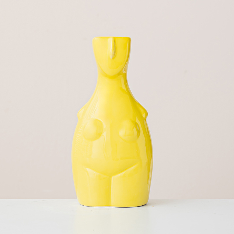 Yellow female silhouette body vase with abstract curves on minimalist beige background, modern sculptural decor