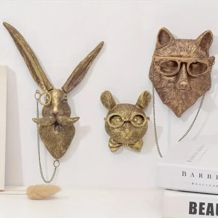 Gold animal head wall decor (stag/rabbit/fox) with vintage glasses & chains, displayed on white textured wall with stacked books and dried florals | Luxury faux taxidermy art for modern interiors