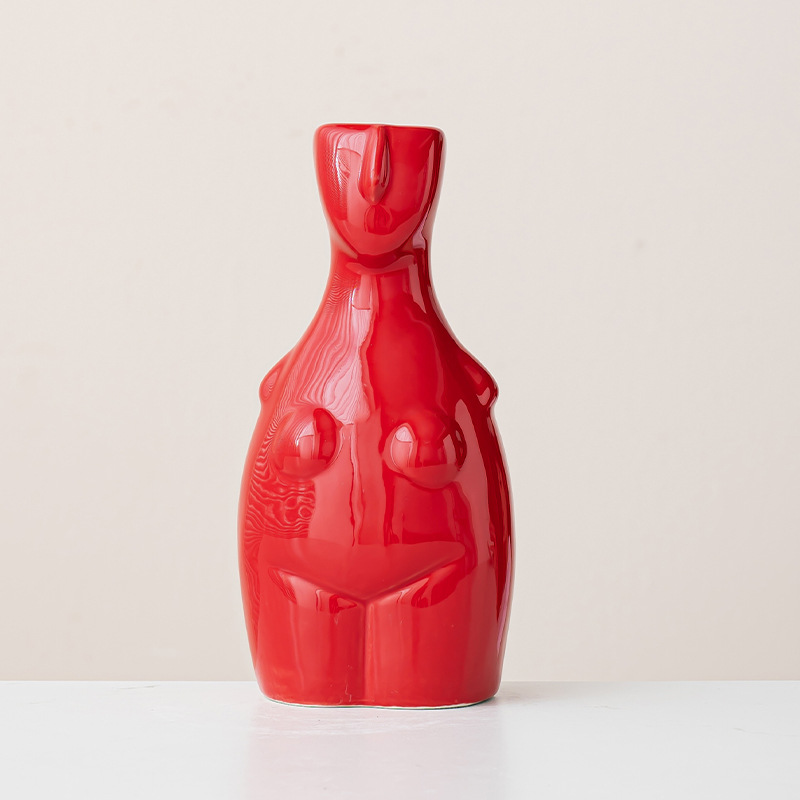 Modern red sculptural vase with female body contours, minimalist beige background, centered composition